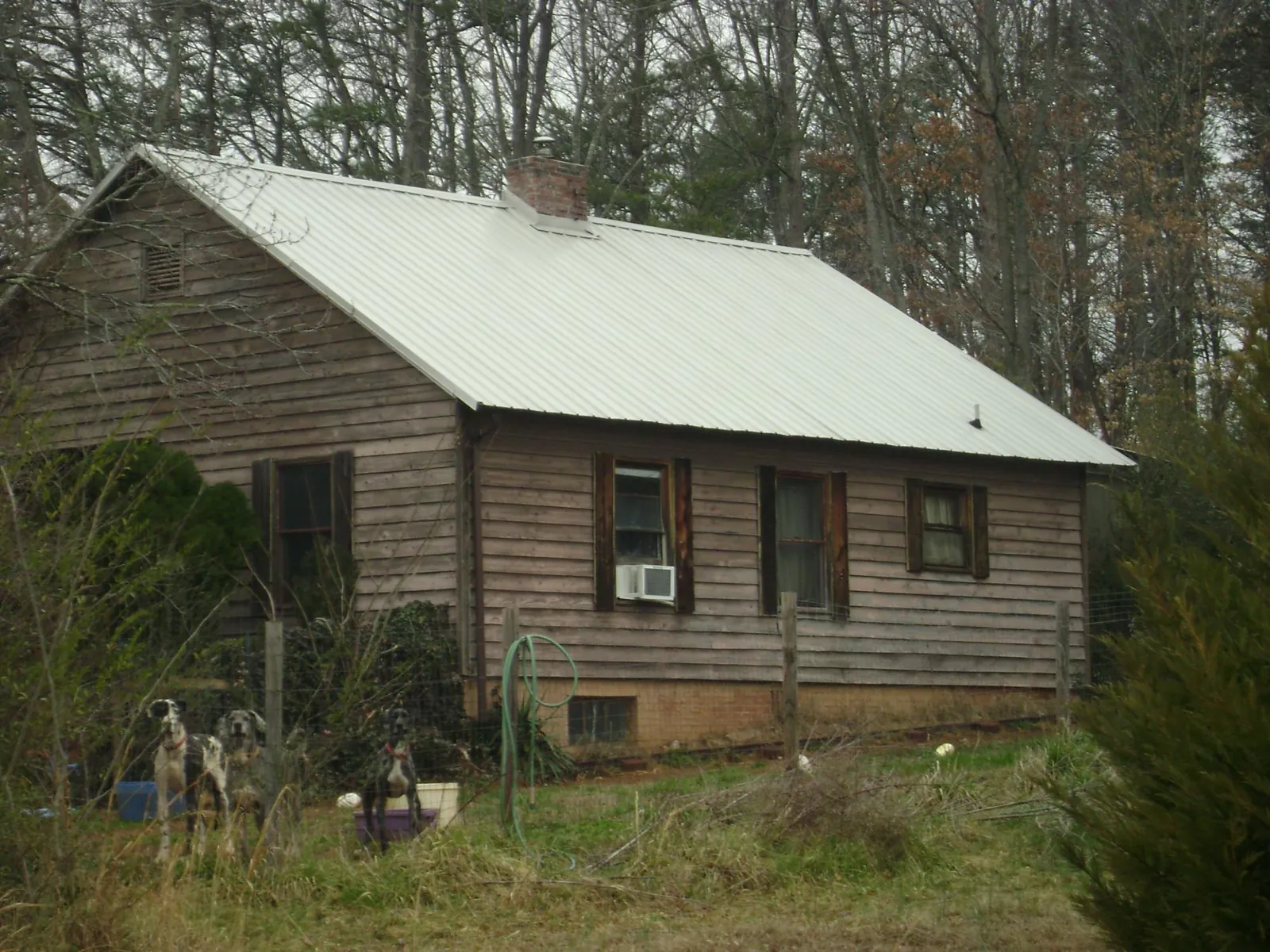 White metal roof on an old wood sided farmhouse, from a Metal Roof Installation job in Bailey